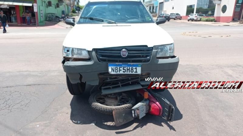 Moto vai parar embaixo de carro após colisão no Centro de Rolim de Moura Moto vai parar embaixo de carro após colisão no Centro de Rolim de Moura